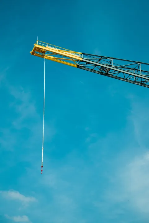 青空を背景にしたタワークレーンのジブとフック